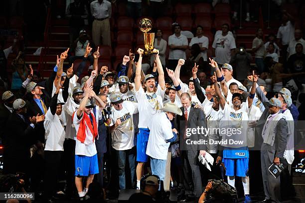 Dirk Nowitzki of the Dallas Mavericks holds the NBA Championship trophy as he and his teammates celebrate defeating the Miami Heat in Game Six of the...