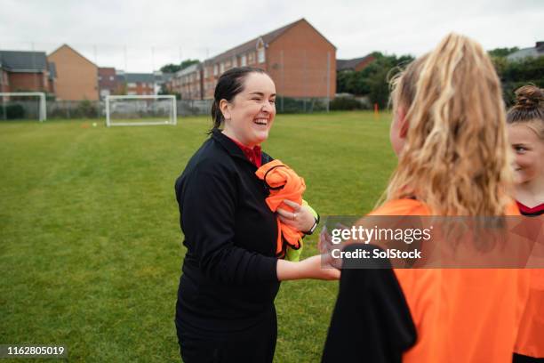 fußballtrainer lächelnd - startnummer stock-fotos und bilder