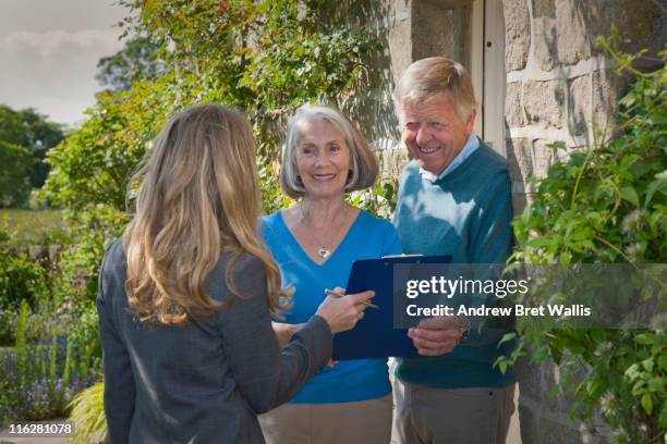 door step researcher talking to senior couple - kundenwerber stock-fotos und bilder