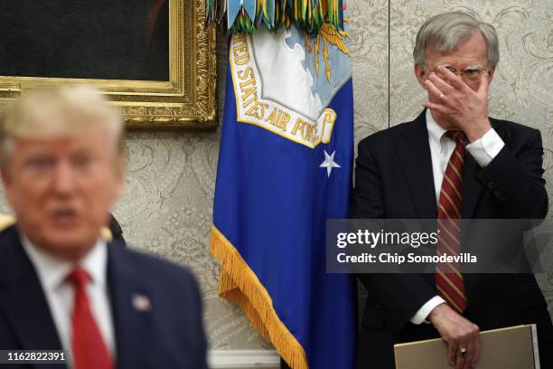 White House National Security Advisor John Bolton listens to U.S. President Donald Trump as he and Dutch Prime Minister Mark Rutte talk to reporters...