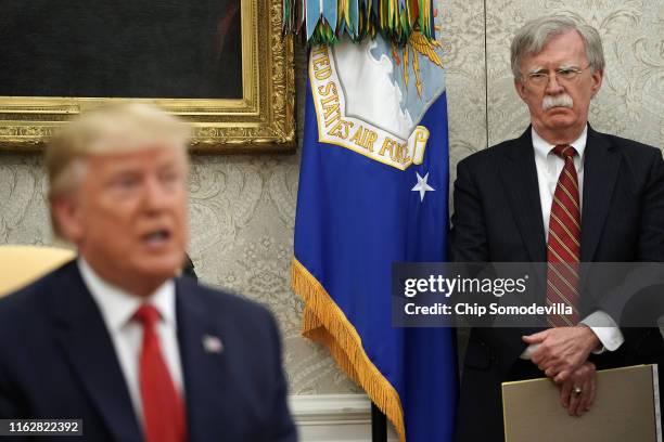 White House National Security Advisor John Bolton listens to U.S. President Donald Trump as he and Dutch Prime Minister Mark Rutte talk to reporters...