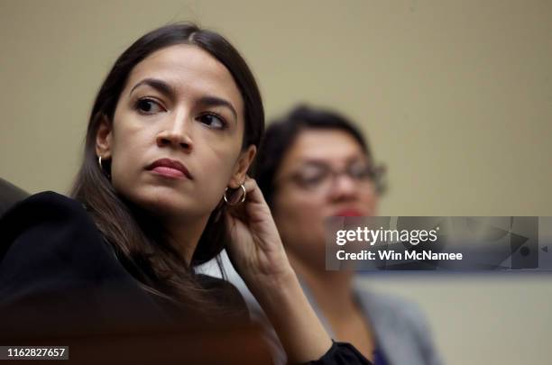 Rep. Alexandria Ocasio-Cortez and Rep. Rashida Tlaib listen to testimony from acting Homeland Security Secretary Kevin McAleenan while he testifies...