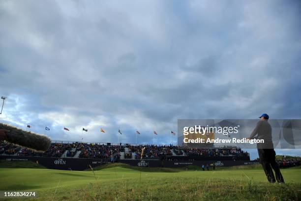 Tiger Woods of the United States plays his third shot on the 18th hole during the first round of the 148th Open Championship held on the Dunluce...