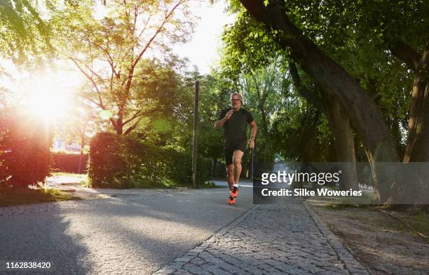 portrait of an active senior man doing exercise in the city of berlin - man running city stock pictures, royalty-free photos & images
