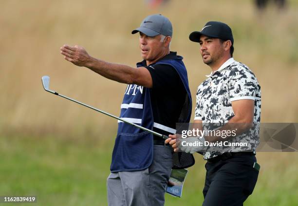 Jason Day of Australia decides on his line for his second shot on the 18th hole with his caddie S Steve Williams during the first round of the 148th...
