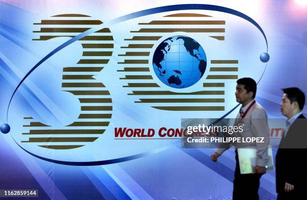 Visitors walk by a billboard at the 3G World Congress and Exhibition 2005 in Hong Kong, 16 November 2005. The 3G World Congress and Exhibition, which...