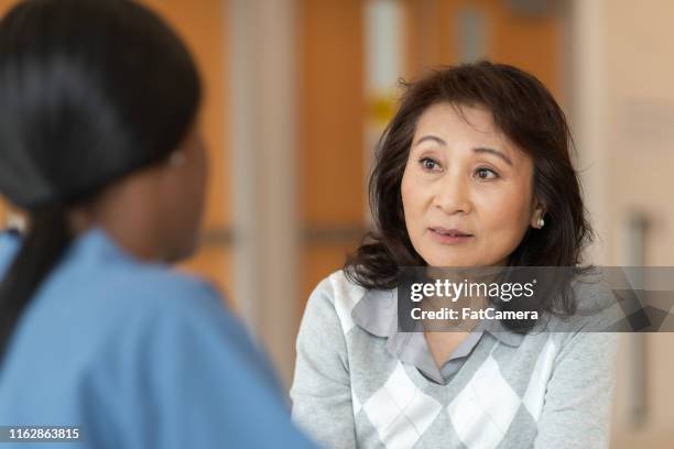 etnische vrouwelijke verpleegster helpt patiënt met astma - copd patient stockfoto's en -beelden