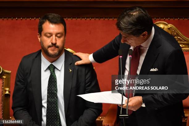 Italian Prime Minister Giuseppe Conte touches Deputy Prime Minister and Interior Minister Matteo Salvini's shoulder as he delivers a speech at the...