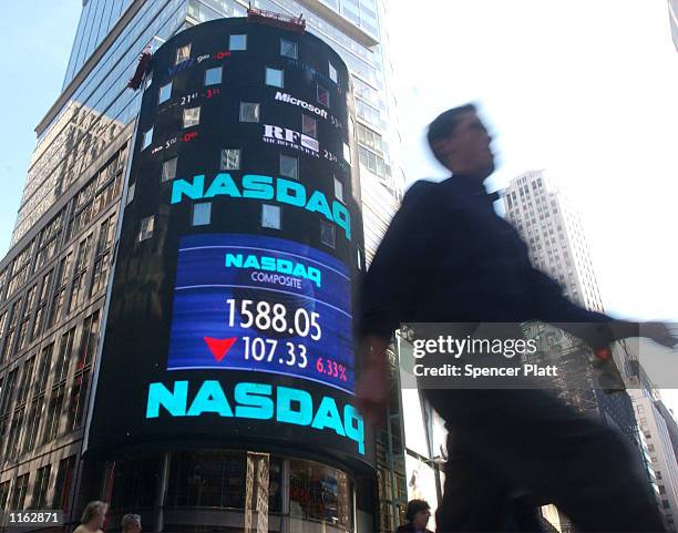 Man walks past the NASDAQ stock market September 17, 2001 in Times Square in New York. The United States, still recovering from last week's attacks...