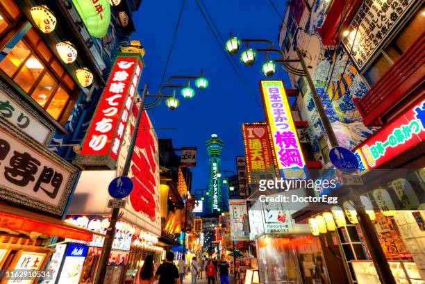 illumination of shinsekai and tsutenkaku tower at night, osaka, japan - osaka stock pictures, royalty-free photos & images