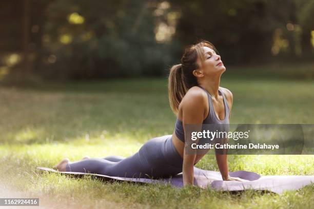 a woman praticing yoga in a park - pilates 個照片及圖片檔