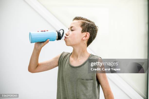 male teenager drinking water after exercise - niño-tomando-agua fotografías e imágenes de stock
