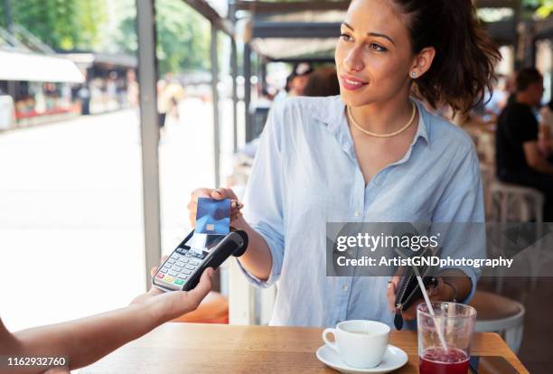 woman making card payment. - customers pay with contactless cards imagens e fotografias de stock