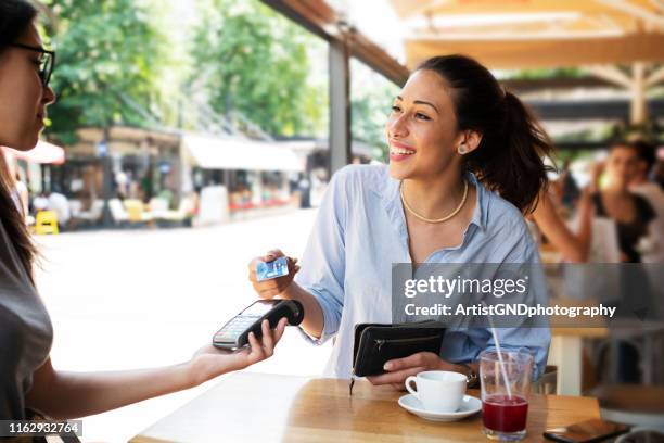 mujer haciendo el pago con tarjeta. - red card fotografías e imágenes de stock