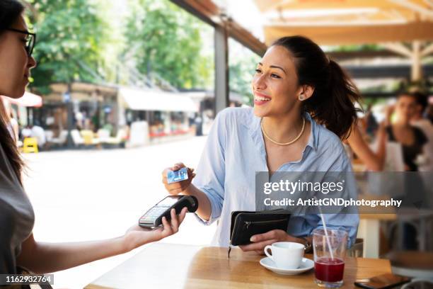 woman making card payment. - customers pay with contactless cards imagens e fotografias de stock