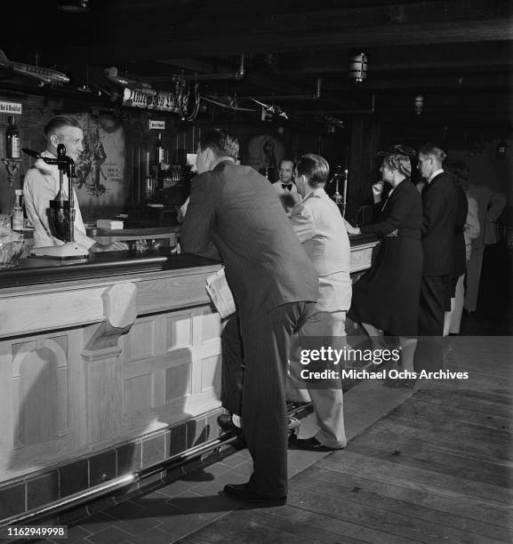 Customers standing at the bar in the 21 Club, restaurant and speakeasy on West 52nd Street in New York City, US, September 1945.