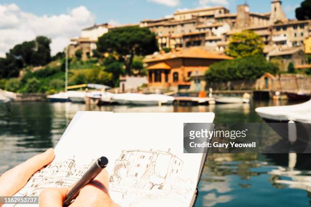 Woman drawing a hilltown of Bolsena in Italy