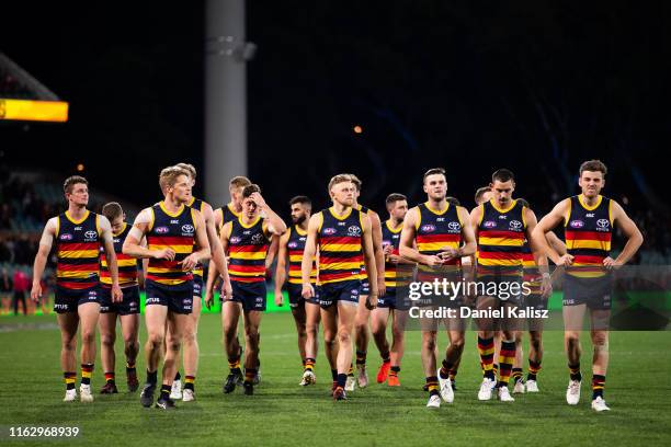 Adelaide Crows players walk from the ground looking dejected during the round 18 AFL match between the Adelaide Crows and the Essendon Bombers at...