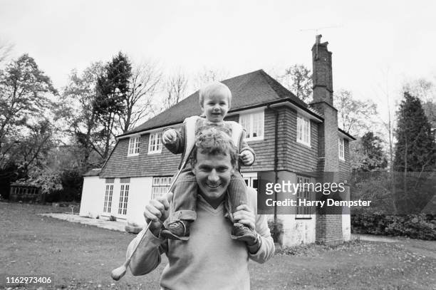 Scottish professional golfer Sandy Lyle carrying his child on his shoulders at their family home, UK, 28th November 1984.