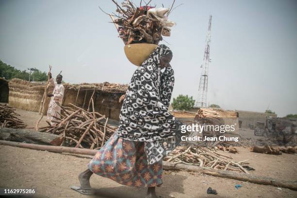 Woman carries firewoods inside an IDP camp on April 21, 2019 in Maiduguri, Nigeria. General elections were held in Nigeria on 23 February 2019 to...