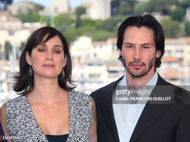 Actor Keanu Reeves and Canadian-born actress Carrie-Anne Moss pose for photographers on a terrace of the Palais des festivals during the photocall...