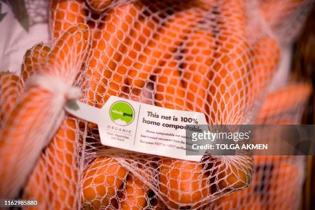 Carrots packaged in a compostable plastic-free net made from beechwood are seen on sale at Budgens supermarket in Belsize Park, north London on July...