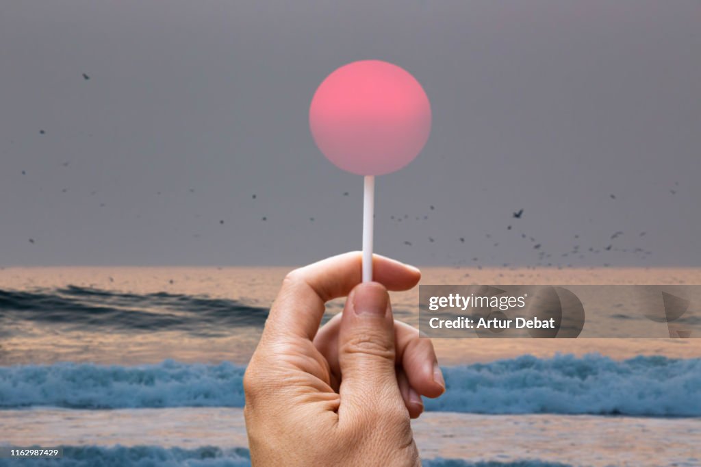 Creative picture of sun like a lollipop in the beach.