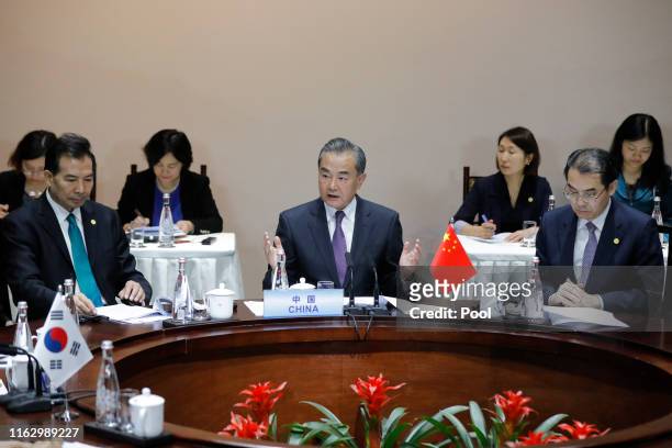 Chinese Foreign Minister Wang Yi speaks with South Korean Foreign Minister Kang Kyung-wha and Japanese Foreign Minister Taro Kono during a meeting of...