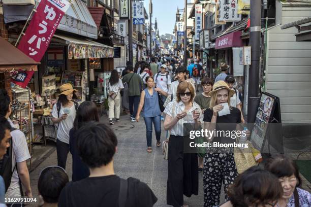 People walk along the Komachi Street lined with craft shops and restaurants in Kamakura, Kanagawa Prefecture, Japan, on Saturday, Aug. 17, 2019. The...