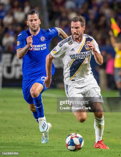 Chris Pontius of Los Angeles Galaxy moves the ball upfield as Edgar of Cruz Azul defends during the Semifinal of the 2019 Leagues Cup match between...