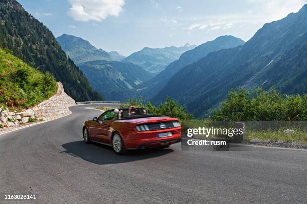 convertible car driving on silvretta-bielerhohe high alpine road in vorarlberg, austria. - mountain road stock pictures, royalty-free photos & images