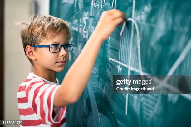 高度な数学的問題を解決する小さな男の子 - 天才 ストックフォトと画像