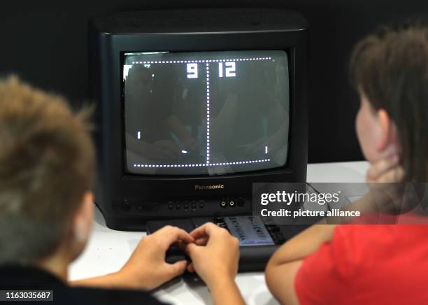 August 2019, North Rhine-Westphalia, Cologne: Visitors to the Gamescom trade fair will be playing Ping Pong on a television set in the retro games...