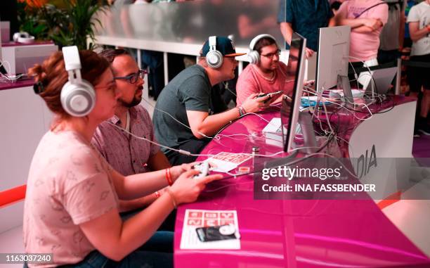 Visitors play the cloud-gaming based "Doom" at the stand of Google Stadia during the Video games trade fair Gamescom in Cologne, western Germany, on...