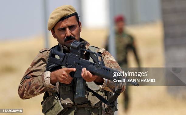 Iraqi Kurdish Peshmerga forces using German-made assault rifles attend a training session by German military officers during the German Defence...