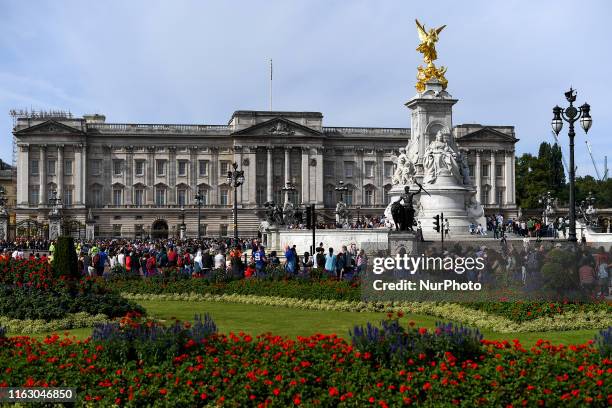 Tourists are seen at St Jamess Park and outside Buckingham Palace in London, on August 21, 2019.