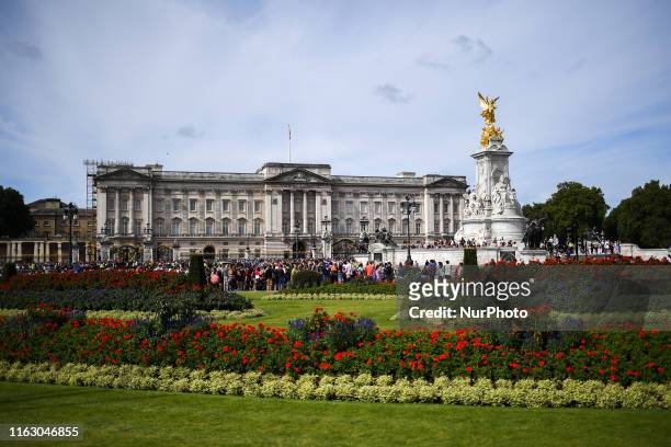 Tourists are seen at St Jamess Park and outside Buckingham Palace in London, on August 21, 2019.