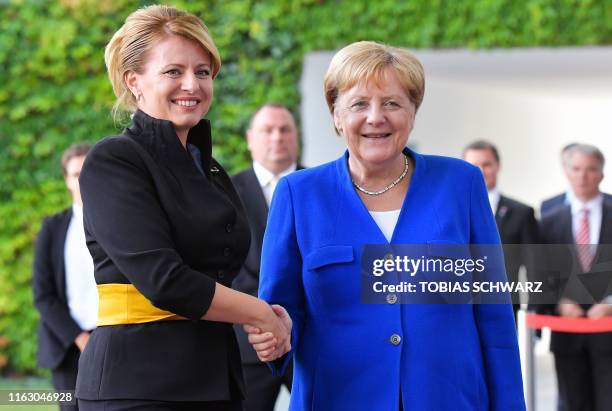 German Chancellor Angela Merkel shakes hands with Slovakia's President Zuzana Caputova as she arrives for a meeting at the Chancellery on August 21,...