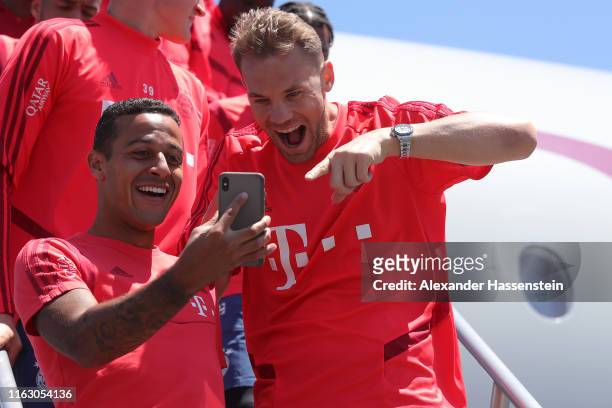 Thiago Alacantara of FC Bayern Muenchen jokes with team mate Manuel Neuer at the Los Angeles International Airport prior to depart with the team...