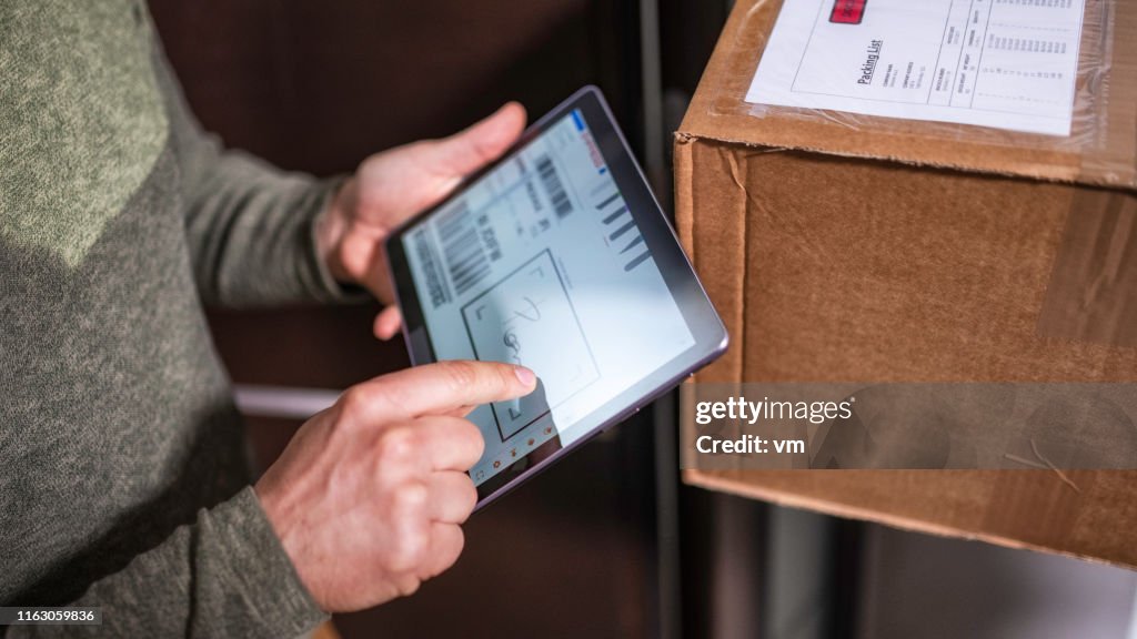 Customer signing receipt of home delivery on a tablet