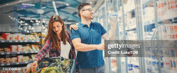 ein glückliches paar in einem lebensmittelgeschäft - couple in supermarket stock-fotos und bilder