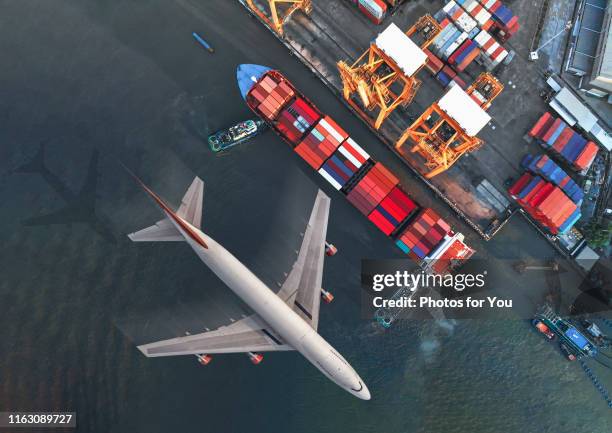 aerial view/a large cargo ship is passing through a port with cargo loading, loading containers to transport to the big city. - avión de carga fotografías e imágenes de stock