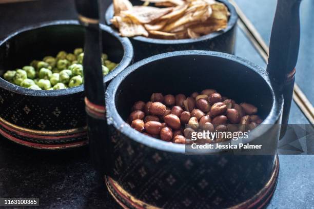 bowl of snacks - peanuts, dried peas and dried bananas - raffles hotel stockfoto's en -beelden