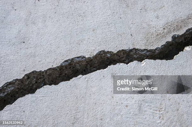 large crack in painted concrete - earthquake stock pictures, royalty-free photos & images