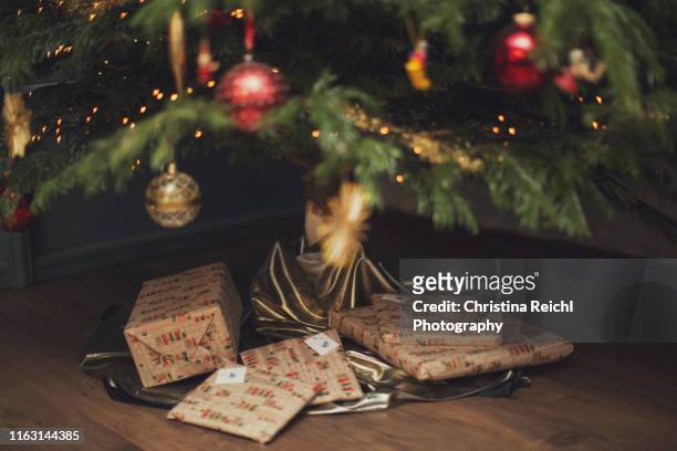 christmas presents under decorated tree - weihnachtsbaum stock-fotos und bilder