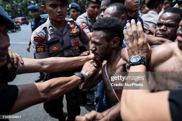 Papuan students taking part in a rally push toward a line of police and military blocking them during a rally in Jakarta, Indonesia, on August 22,...