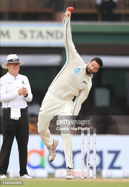 New Zealand cricketer Will Somerville delivers a ball as umpire Bruce Oxenford looks on during the first day's play of the second test cricket match...