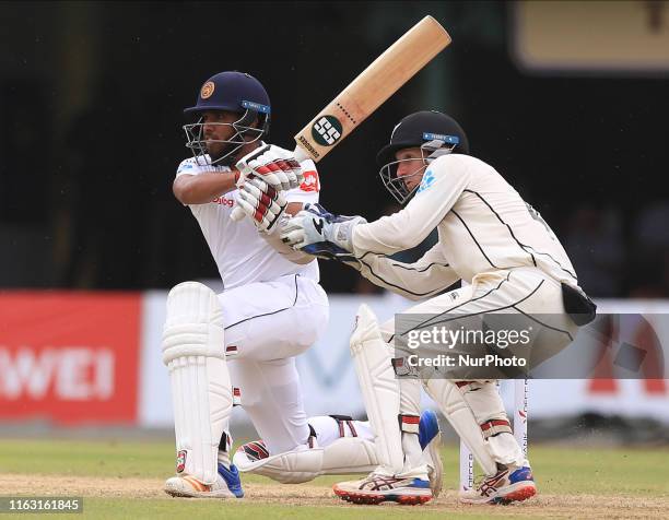 Sri Lankan cricketer Kusal Mendis plays a shot as New Zealand wicket keeper BJ Watling looks on during the first day's play of the second test...