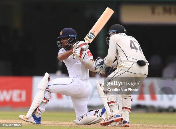 Sri Lankan cricketer Kusal Mendis plays a shot as New Zealand wicket keeper BJ Watling looks on during the first day's play of the second test...