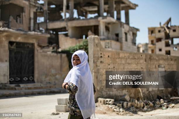 Youth smiles in the northern Syrian city of Raqa, the former Syrian capital of the Islamic State group, on August 21, 2019. The Kurdish-led Syrian...